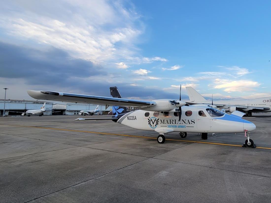 A Tecnam P2012 Traveller in an operator's livery on an apron.