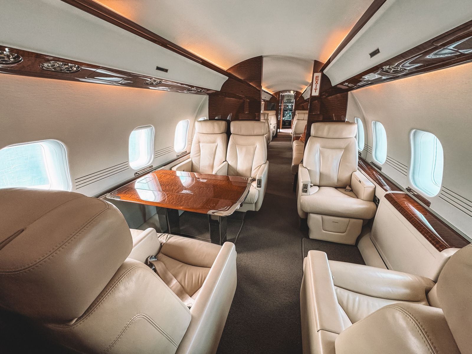 A business jet cabin with a table and club seats.