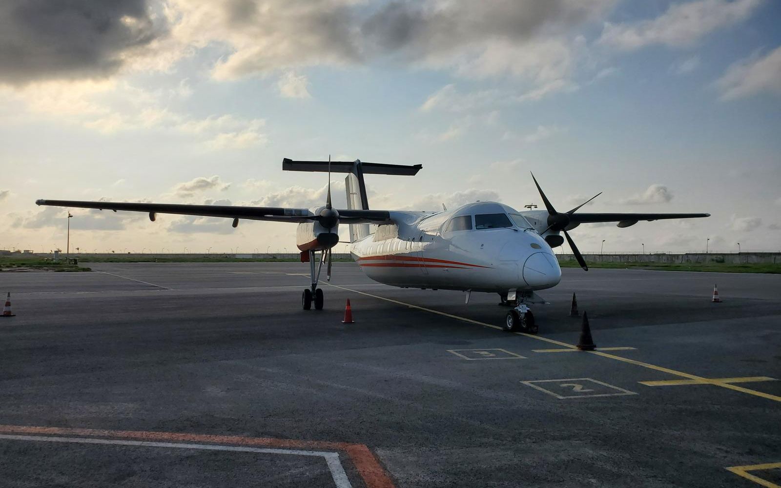 A Dash 8 on the apron at dusk during a delivery flight.