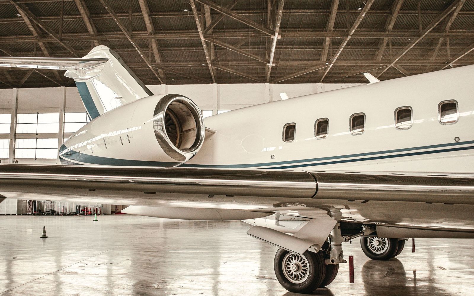 The fuselage and engine of a business jet in a hangar.