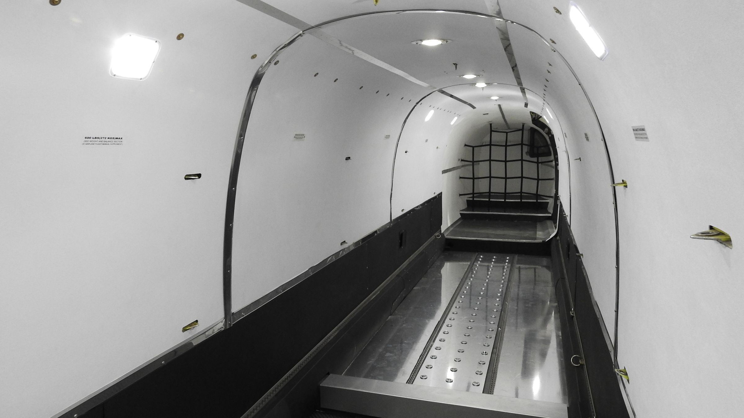 The empty cargo bay of a Beechcraft 1900D freighter with roller floor and cargo net