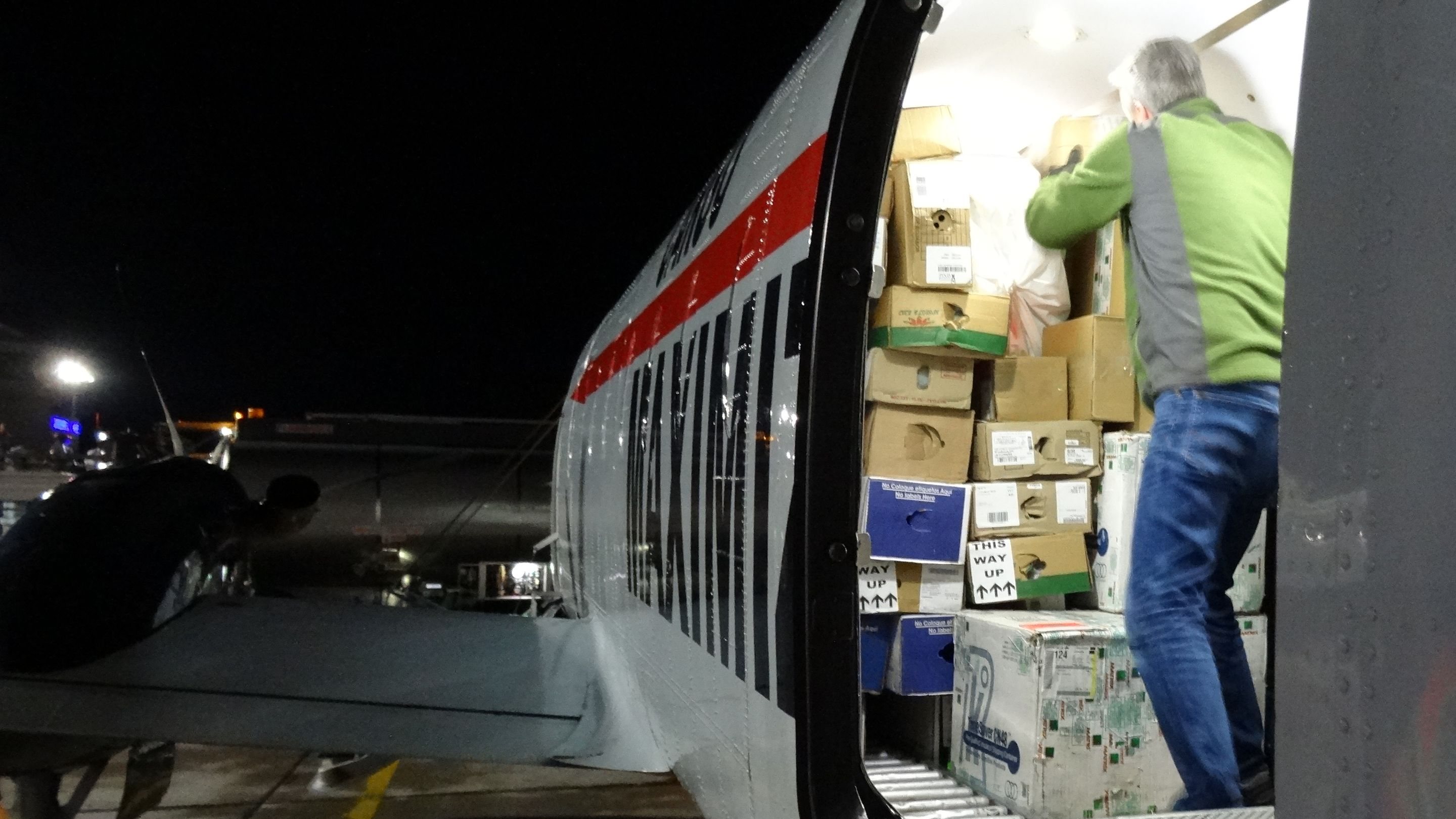 A Beechcraft 1900D freighter being loaded at night