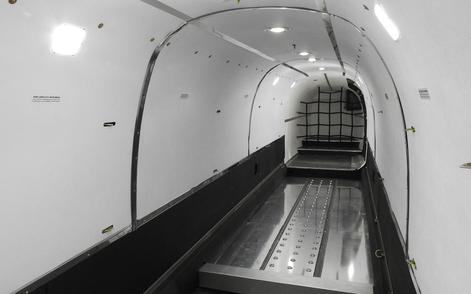 The empty cargo bay of a Beechcraft 1900D freighter with roller floor and cargo net