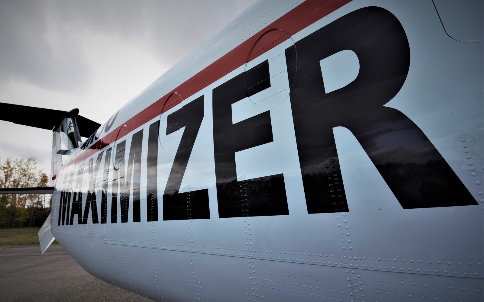 The Maximizer lettering and red stripe on the fuselage of a Beechcraft 1900D